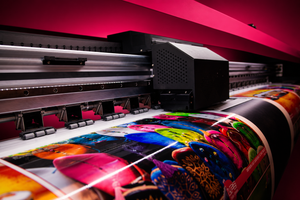 Large-format printer with colorful printed material on a red background